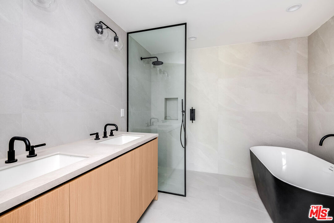 10352 Riverside Drive, Unit 301 Toluca Lake, CA 91602 - Photo 16 of 19 a bathroom with a sink and mirror