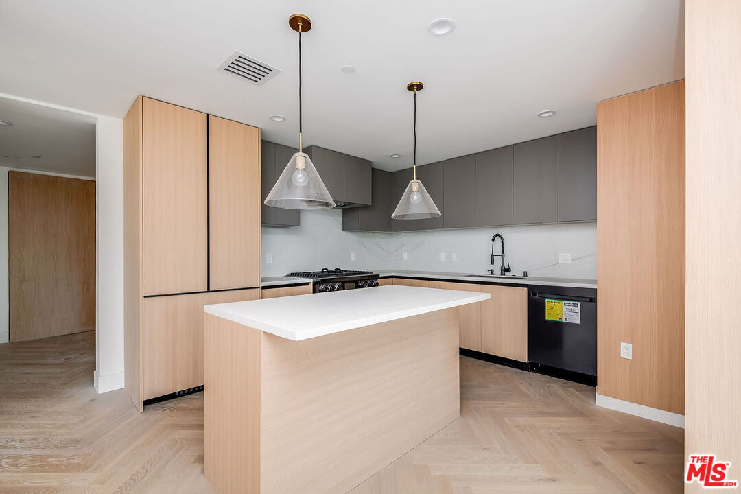10352 Riverside Drive, Unit 301 Toluca Lake, CA 91602 - Photo 5 of 19 a kitchen with stainless steel appliances granite countertop a sink a stove a refrigerator and island