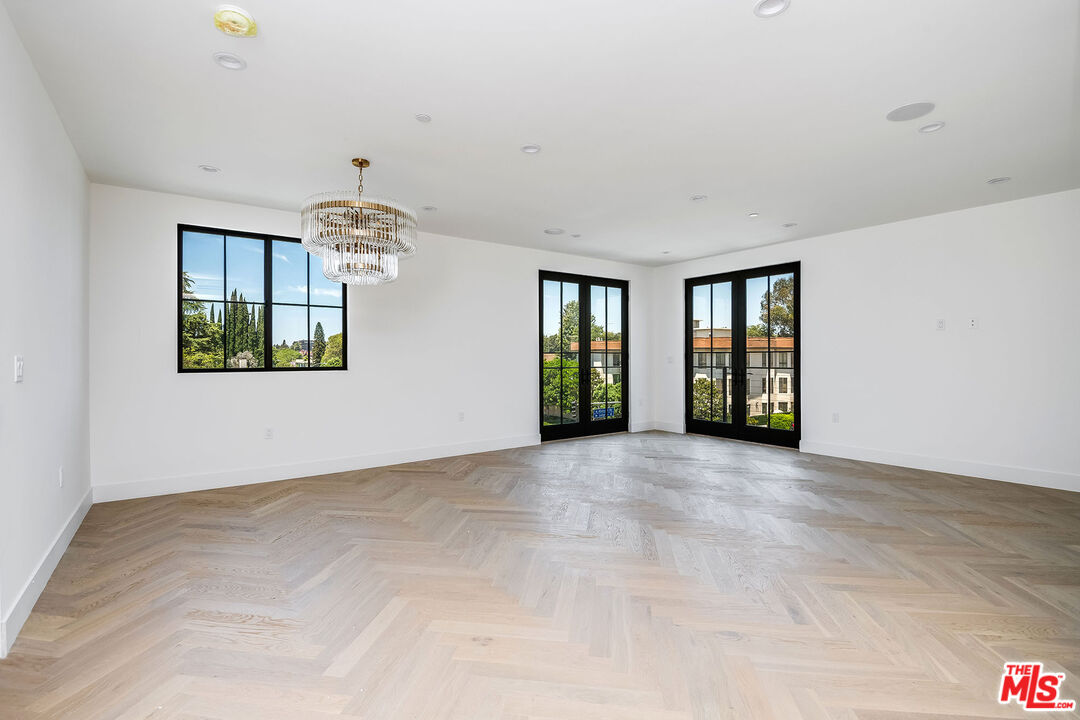 10352 Riverside Drive, Unit 301 Toluca Lake, CA 91602 - Photo 6 of 19 a view of an empty room with chandelier and a window