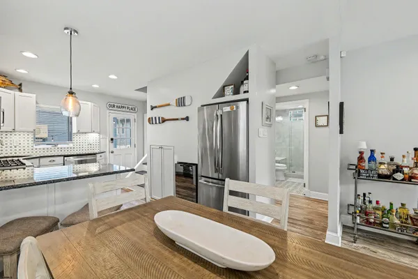 a kitchen with stainless steel appliances a sink a stove a refrigerator cabinets and dining table