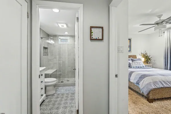 a bathroom with a granite countertop sink a toilet and shower
