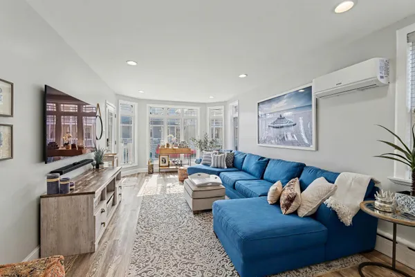a living room with furniture a flat screen tv and a window