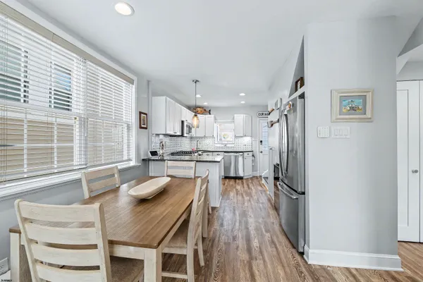 a kitchen with stainless steel appliances granite countertop a sink refrigerator and wooden floor
