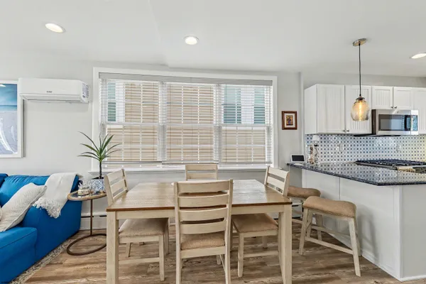 a kitchen with a table chairs a stove and a window