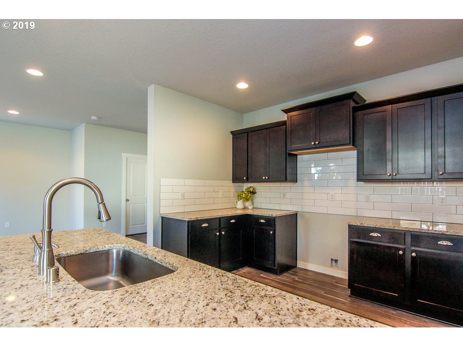 3002 Northeast 171st Street Ridgefield, WA 98642 - Photo 11 of 32 a kitchen with kitchen island granite countertop a sink and cabinets