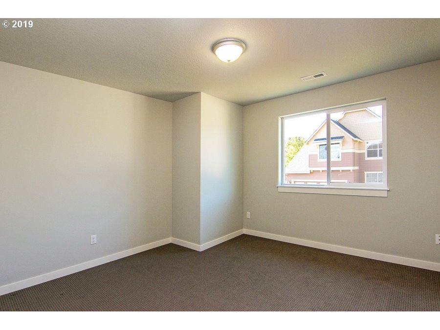 3002 Northeast 171st Street Ridgefield, WA 98642 - Photo 20 of 32 a view of an empty room with wooden floor and a window