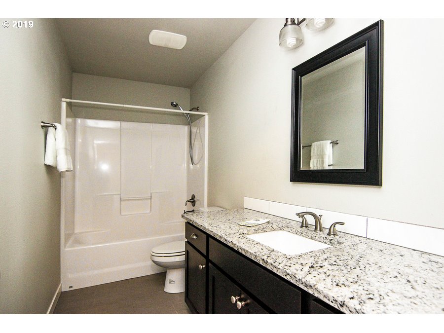 3002 Northeast 171st Street Ridgefield, WA 98642 - Photo 23 of 32 a bathroom with a granite countertop sink toilet and shower