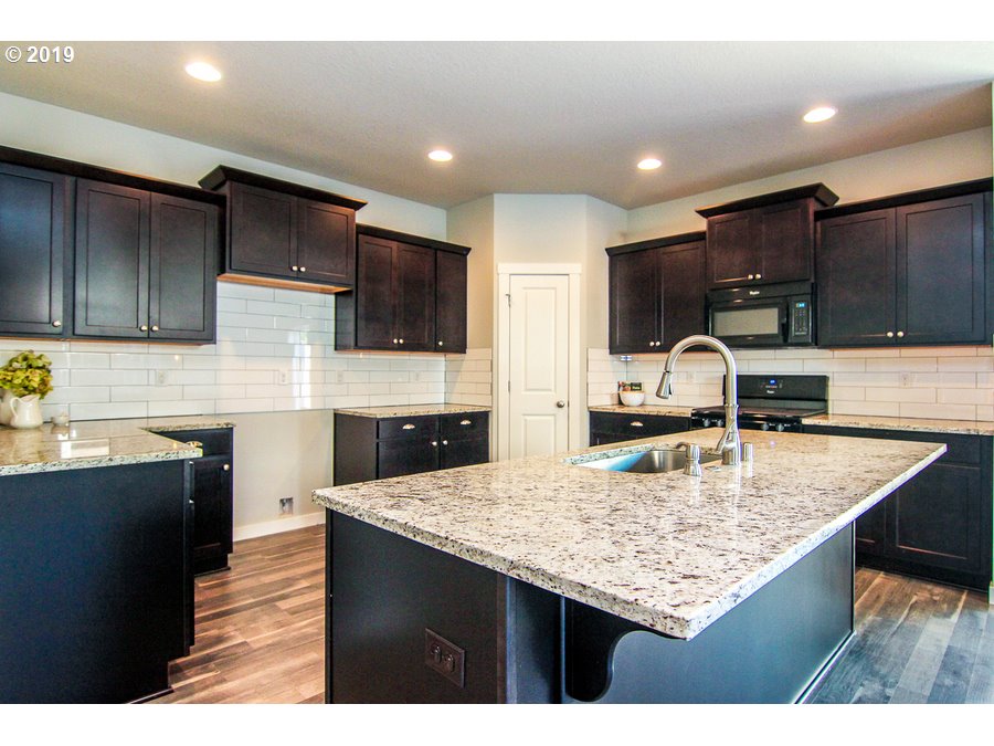 3002 Northeast 171st Street Ridgefield, WA 98642 - Photo 10 of 32 a kitchen with kitchen island granite countertop a sink counter top space appliances and cabinets