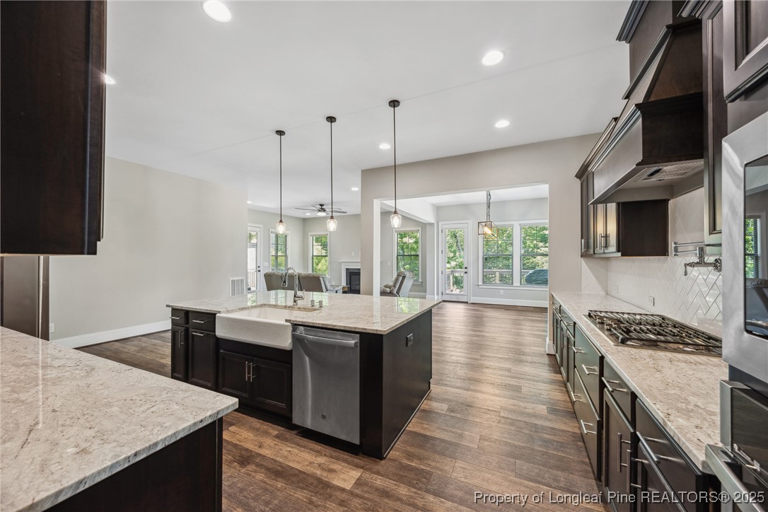 405 Gilpin Way Cary, NC 27519 - Photo 4 of 34 a kitchen with stainless steel appliances kitchen island granite countertop a stove and a sink