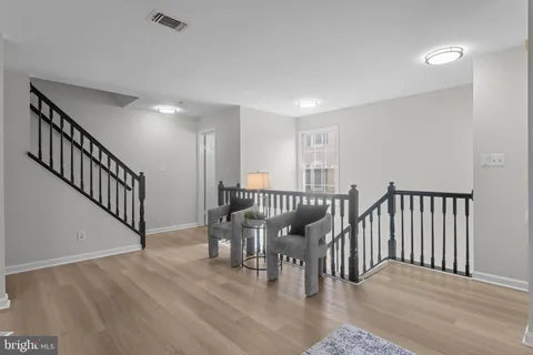 a view of a dining room with furniture a chandelier and wooden floor