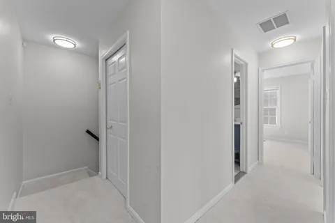 a view of a white house next to a yard