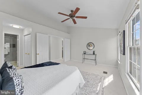 a view of a big yard in front of a brick house with large windows