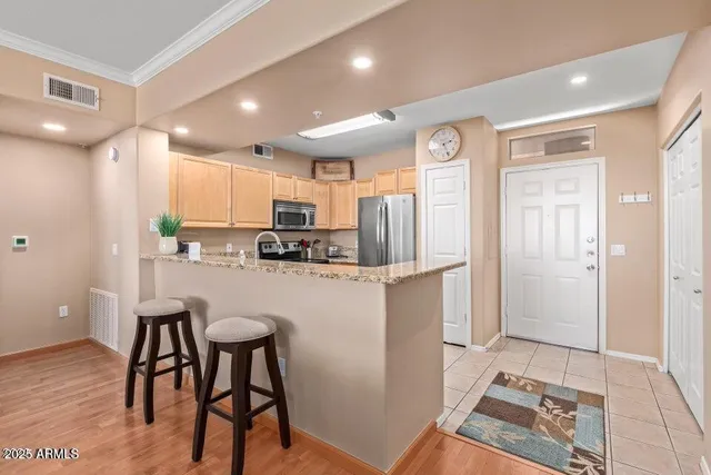 a kitchen with stainless steel appliances granite countertop a refrigerator and a stove top oven