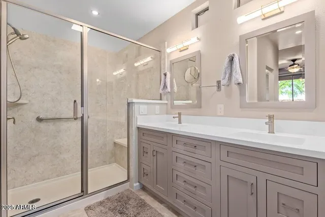 a bathroom with a double vanity sink mirror and shower