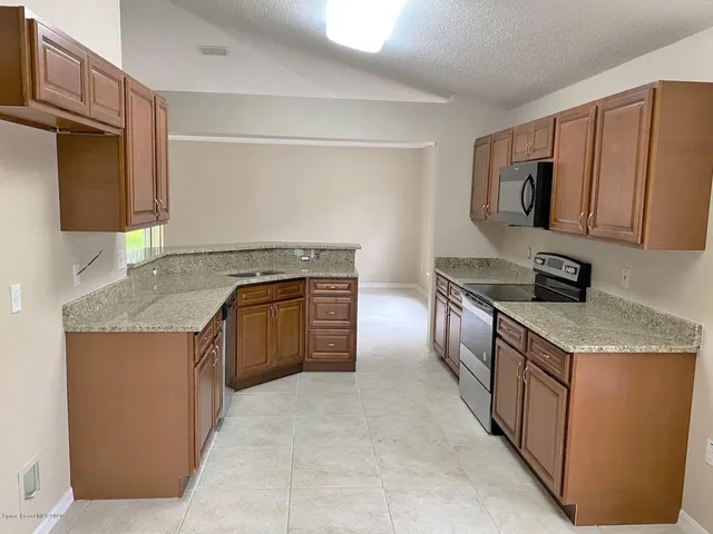 a kitchen with stainless steel appliances granite countertop a stove a sink and a refrigerator