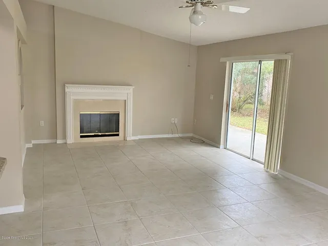a view of an empty room with a fireplace and a window