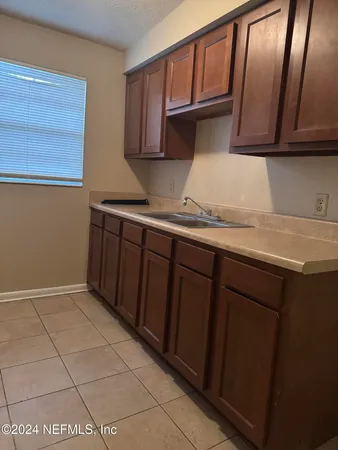 a kitchen with a sink a stove and cabinets