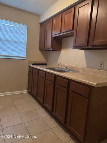 a kitchen with a sink a stove and cabinets