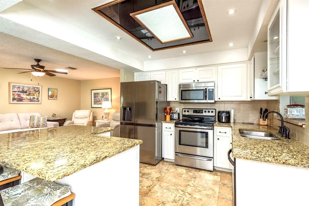 2011 Del-Betmar Road Clearwater, FL 33763 - Photo 19 of 51 a kitchen with kitchen island granite countertop a sink appliances and cabinets