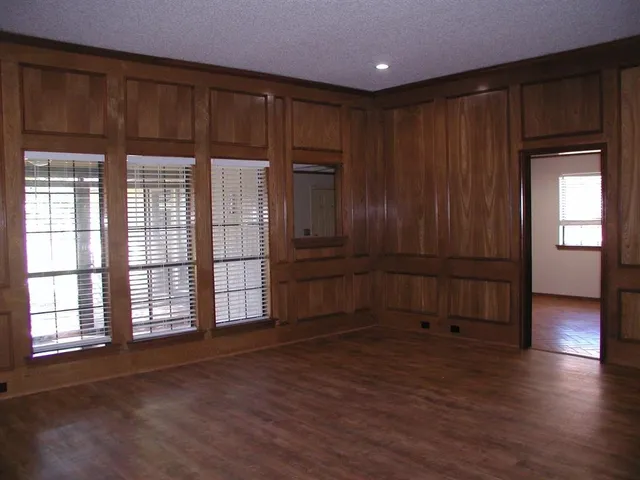 a view of empty room with wooden floor and cabinet