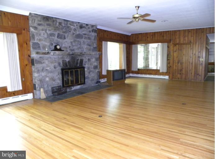 10246 Golf Course Road Fayetteville, PA 17222 - Photo 8 of 11 wooden floor fireplace and windows in a room