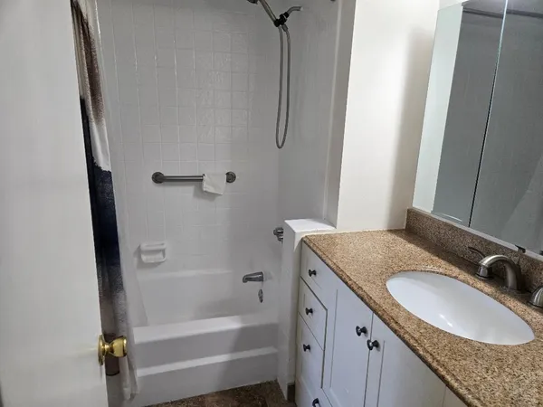 a bathroom with a granite countertop sink and a mirror