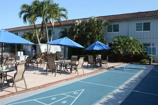 a view of patio with chairs and table under an umbrella