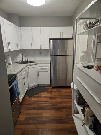 a kitchen with stainless steel appliances granite countertop a refrigerator and a stove top oven