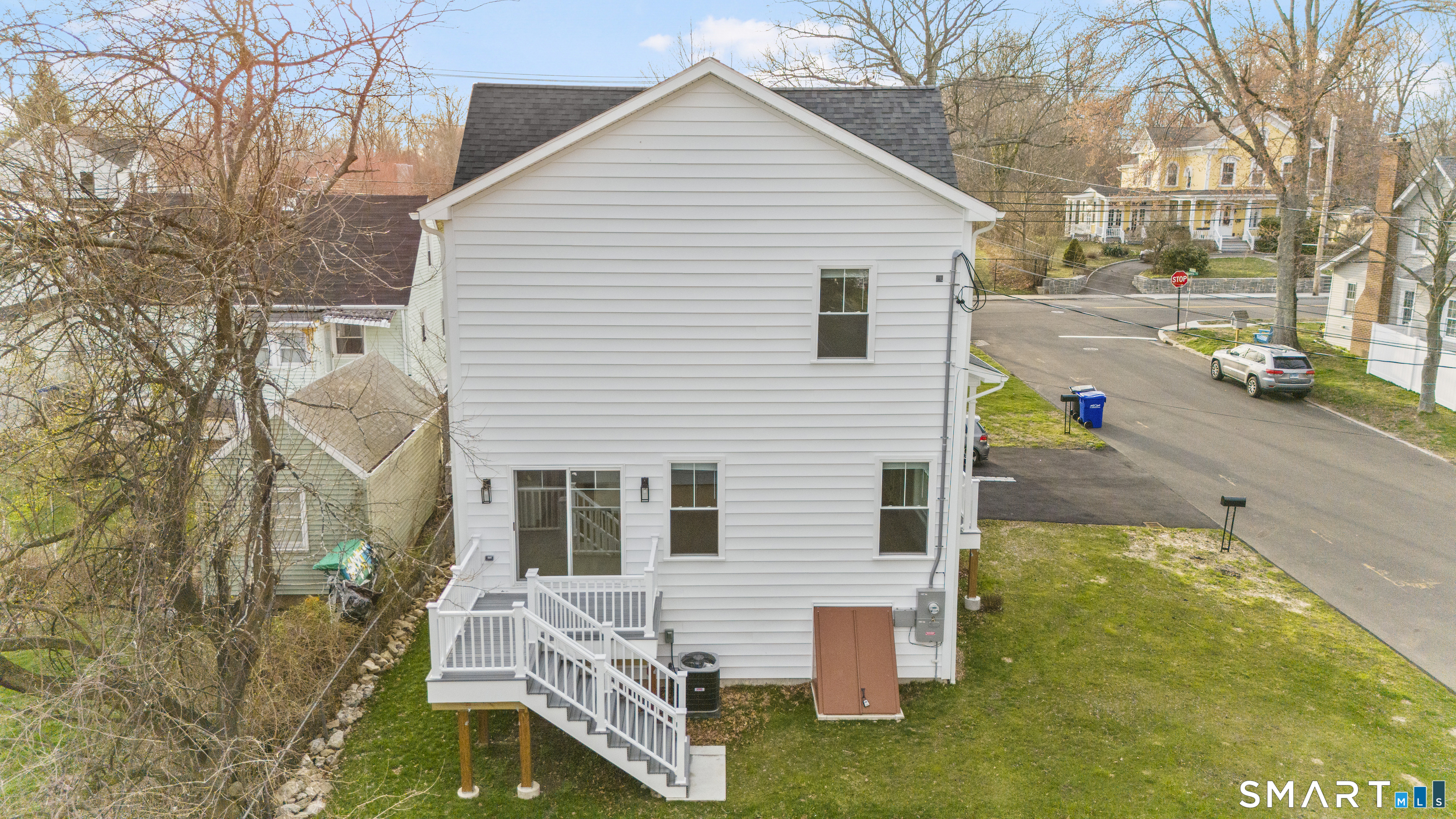 183 Vesper Street Fairfield, CT 06825 - Photo 39 of 40 a view of a white house with a small yard and a large tree
