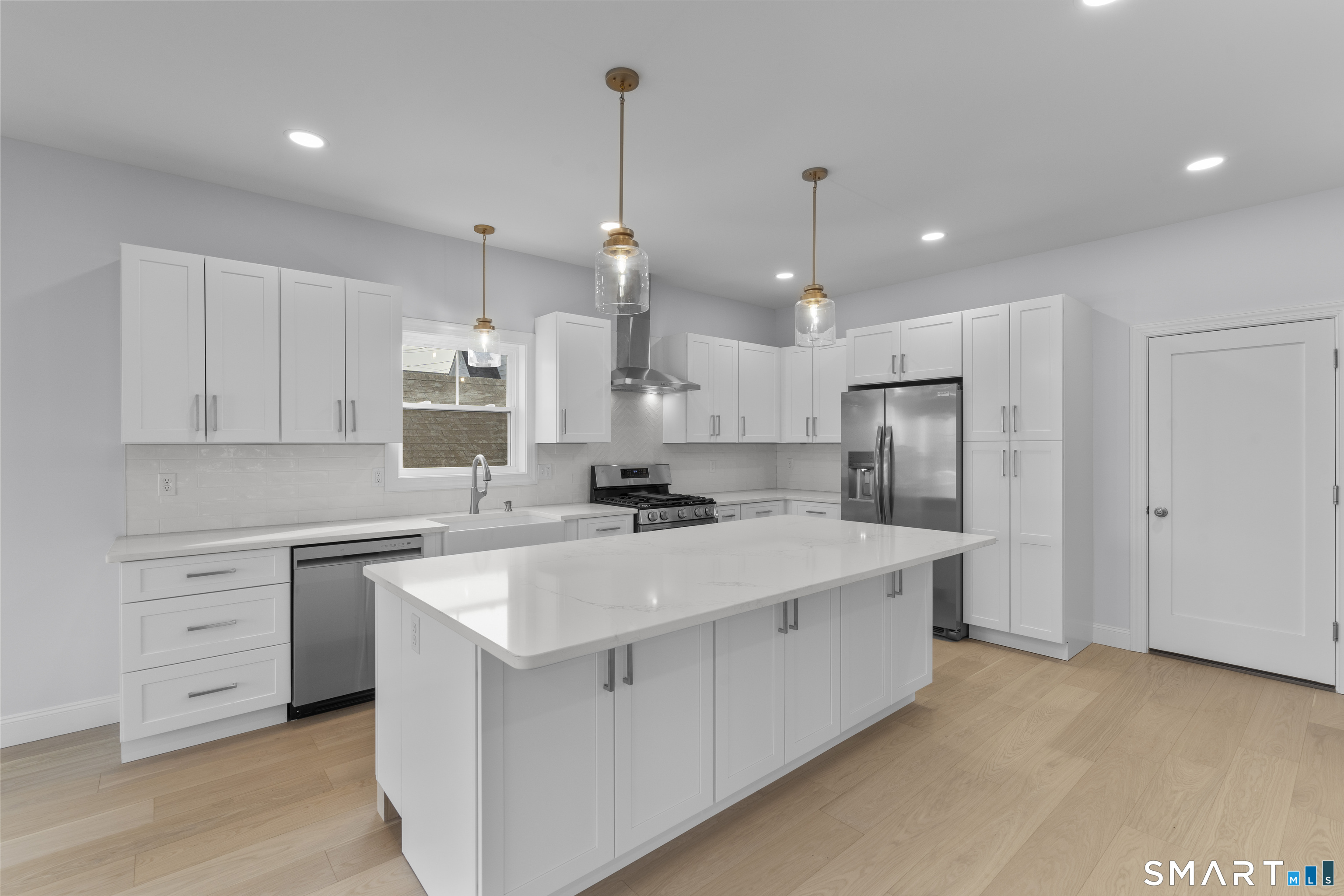 183 Vesper Street Fairfield, CT 06825 - Photo 5 of 40 a kitchen with white cabinets and stainless steel appliances