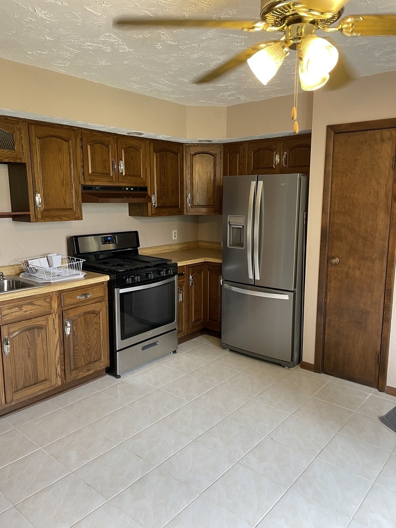 475 Rice Road Gardner, IL 60424 - Photo 17 of 23 a kitchen with stainless steel appliances granite countertop a refrigerator a sink a stove a microwave and island