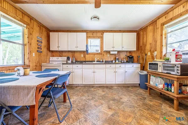 a kitchen with a stove a sink a dining table and chairs