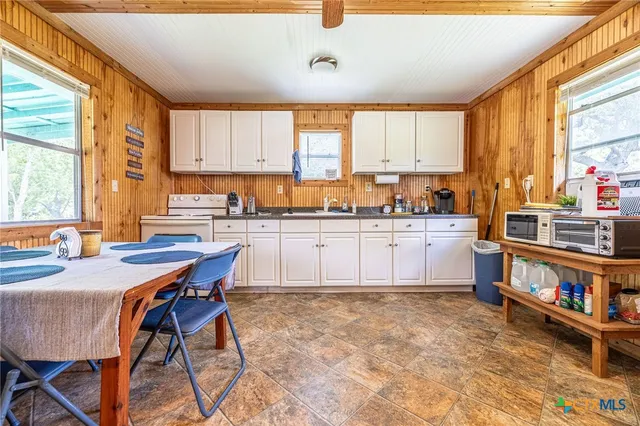 a kitchen with a stove a sink a dining table and chairs