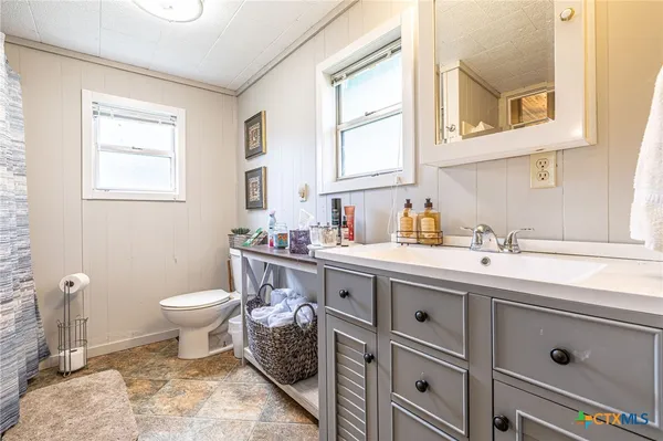 a bathroom with a sink toilet and window