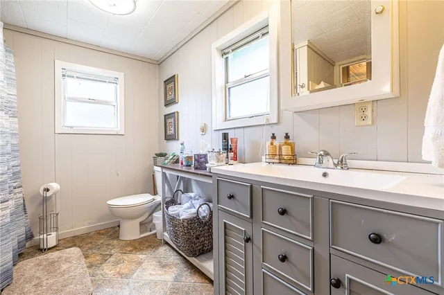 a bathroom with a sink toilet and window