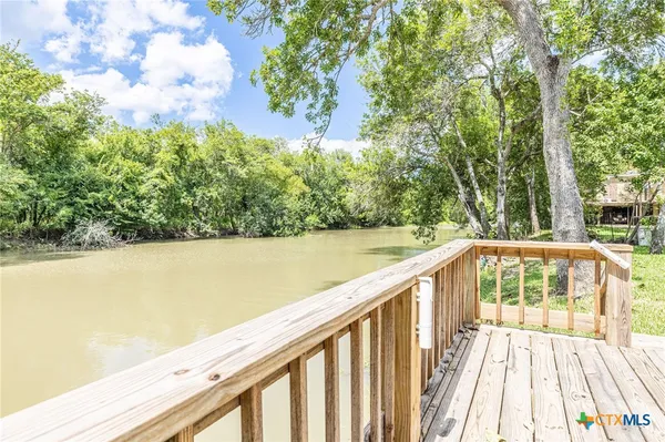 a view of balcony with yard and trees in the background