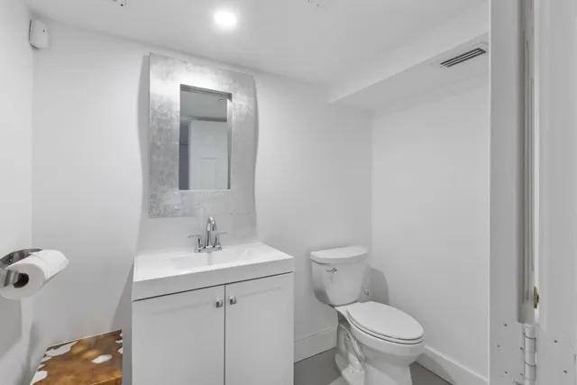 a bathroom with a toilet a sink and mirror