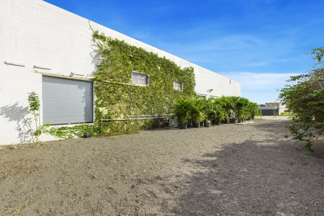 a view of an house with backyard and bushes