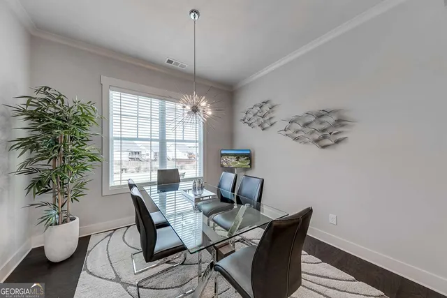 a dining room with furniture potted plants and wooden floor