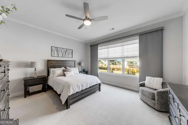 a bedroom with a large bed and a chandelier fan