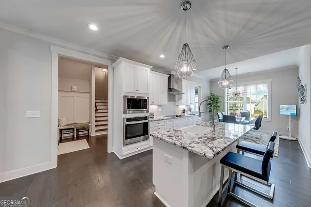 a kitchen with granite countertop kitchen island wooden floor center island and stainless steel appliances