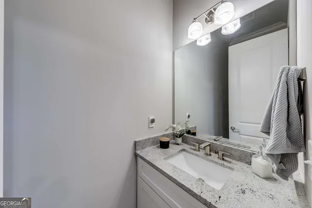 a bathroom with a sink vanity and a mirror