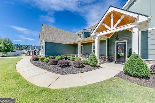 a view of a house with a yard and potted plants