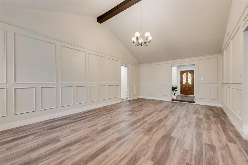 4801 Rock Ridge Court Arlington, TX 76017 - Photo 16 of 27 an empty room with wooden floor chandelier and windows