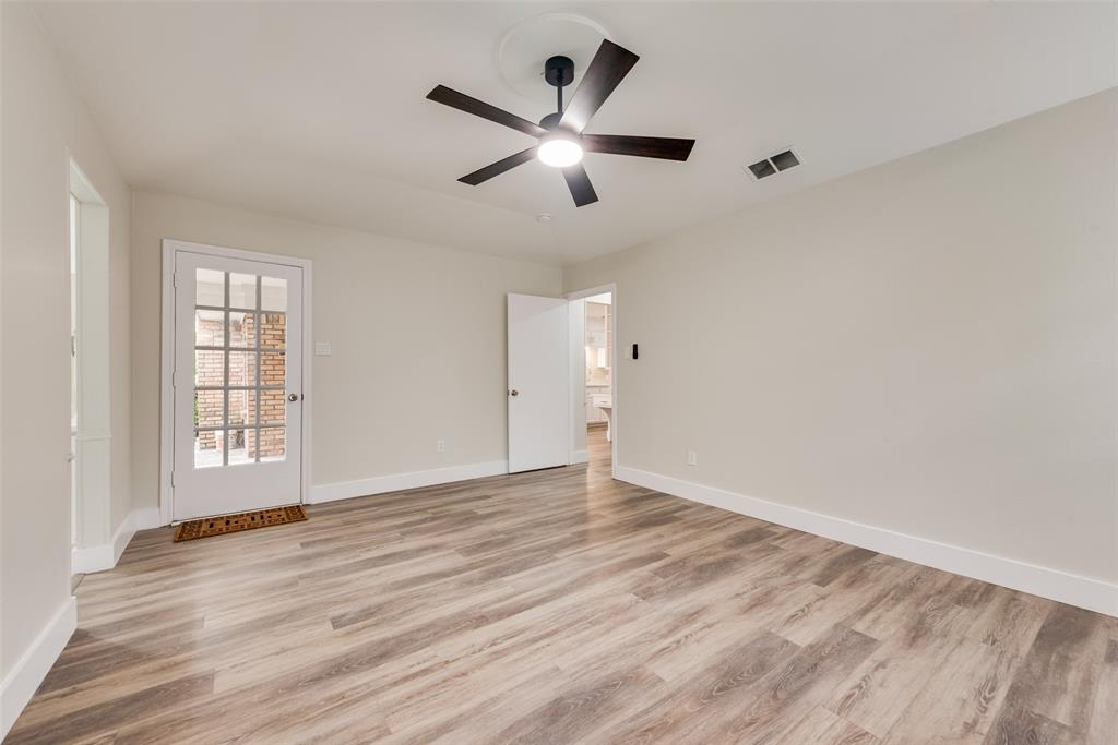 4801 Rock Ridge Court Arlington, TX 76017 - Photo 24 of 27 an empty room with wooden floor fan and windows