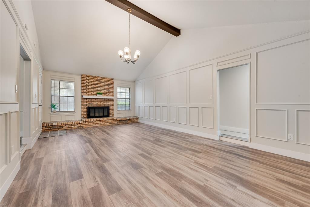 4801 Rock Ridge Court Arlington, TX 76017 - Photo 6 of 27 an empty room with wooden floor fireplace and windows