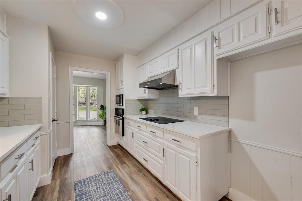 4801 Rock Ridge Court Arlington, TX 76017 - Photo 10 of 27 a kitchen with granite countertop white cabinets and white appliances