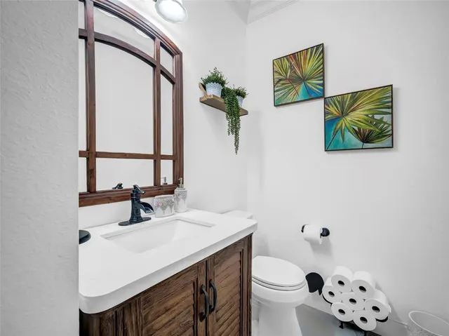 a bathroom with a sink mirror vanity and toilet