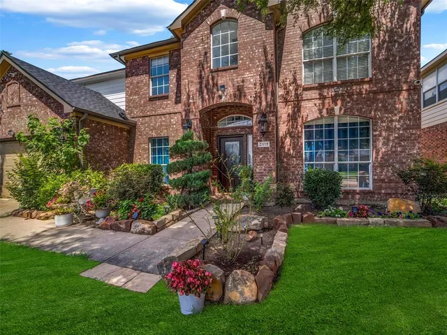 a front view of a house with a garden and plants