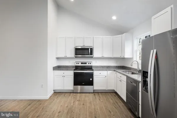 a large white kitchen with a white cabinets and white stainless steel appliances